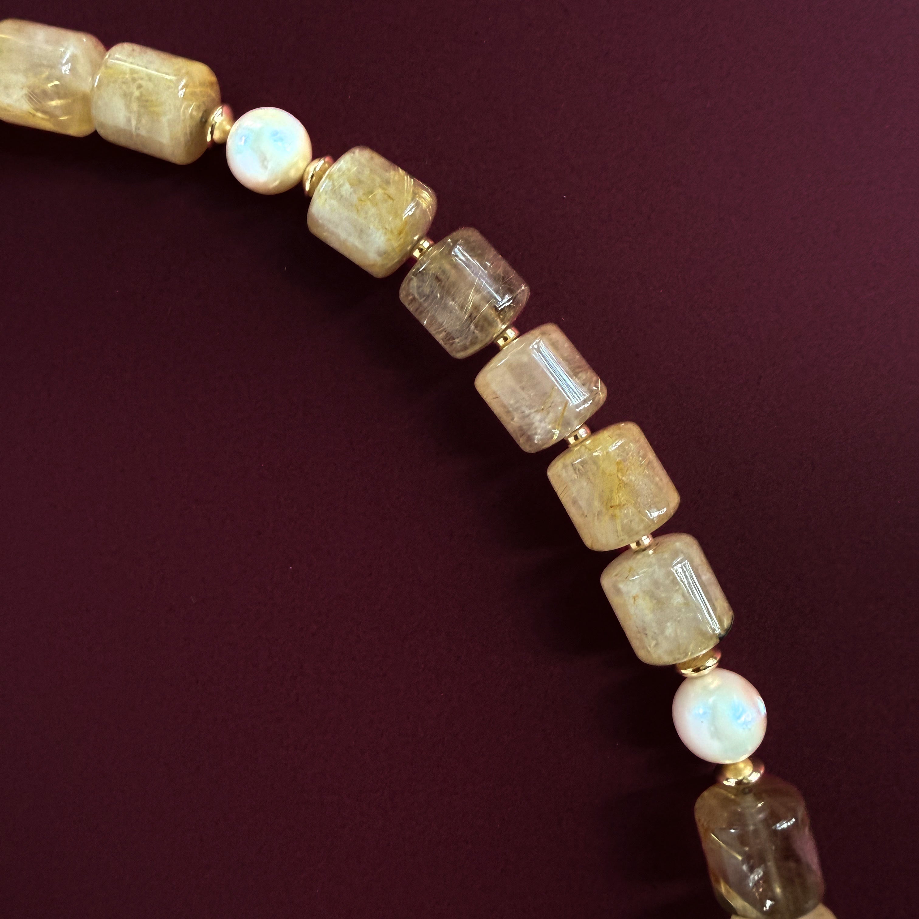 Close-up of natural golden rutilated quartz and freshwater pearls in the Aurelia necklace