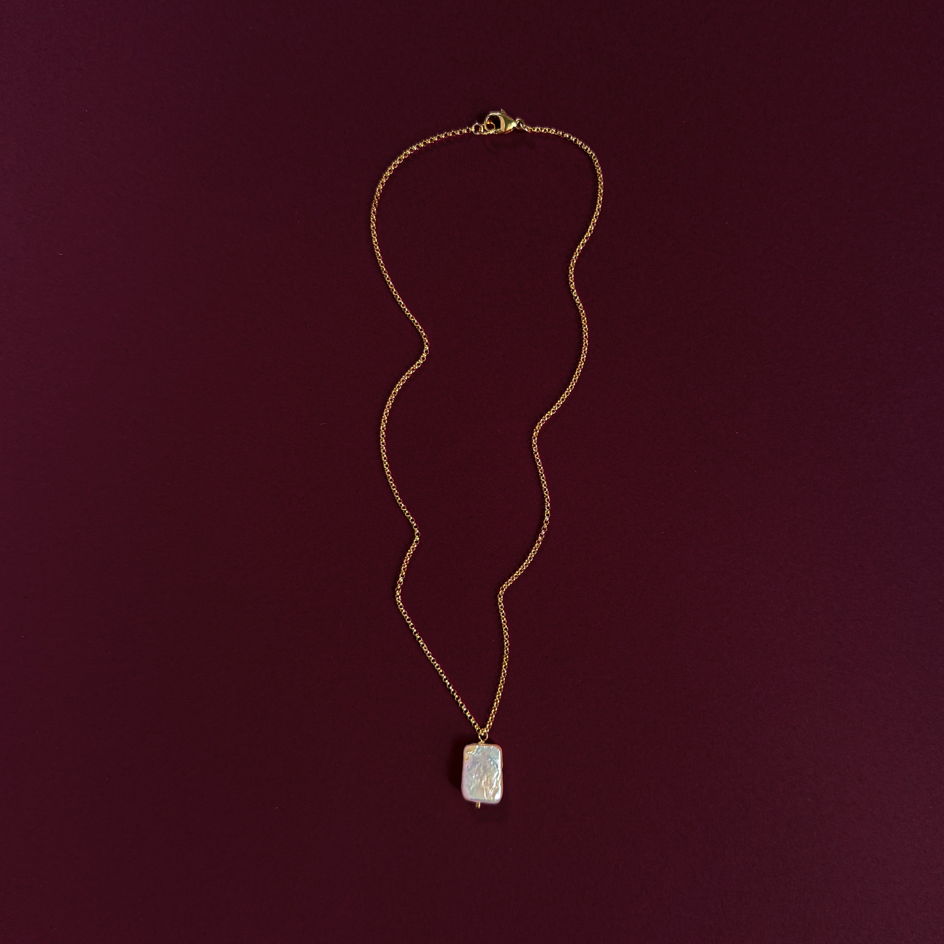 Lucent natural Biwa pearl necklace on 14k gold-filled chain against burgundy background