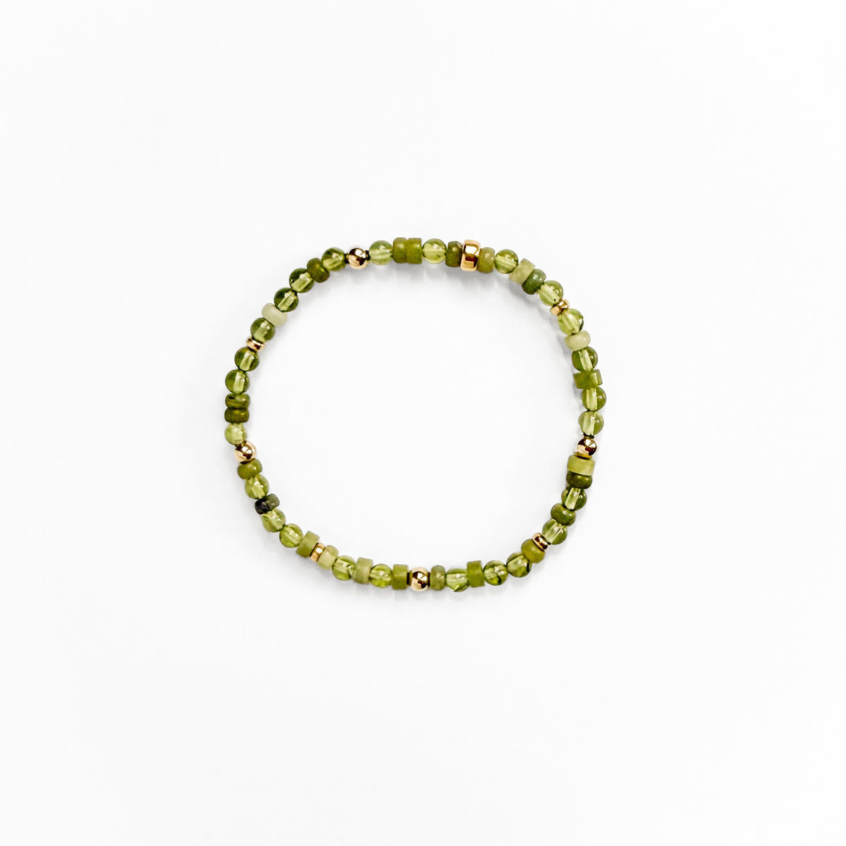 A beaded stretch bracelet made of small green faceted beads with a few metallic gold spacer beads, displayed on a clean white background.